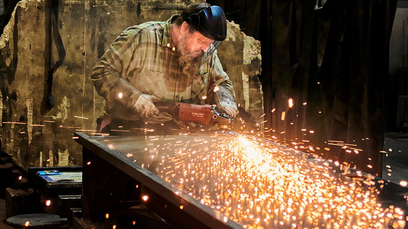 Hier sprühen Funken: Schweißer fertigt ein Schleifbett aus Stahl, auf das später der Schleifwagen montiert wird.