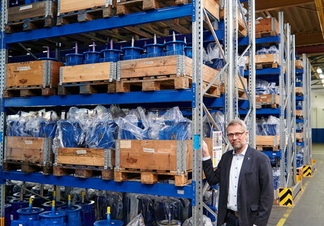 Firmenchef  Wolfram Kuhn vor einem  Lager mit Motoren, das  wegen der Lieferengpässe vergrößert wurde.