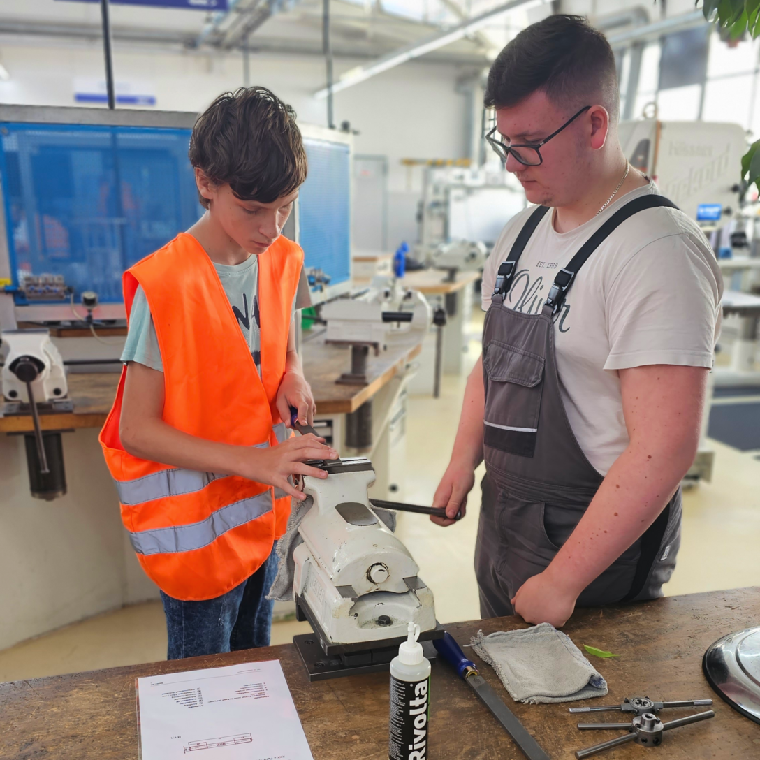 Übung im Bereich Metall: Ein Schüler und ein Auszubildender.