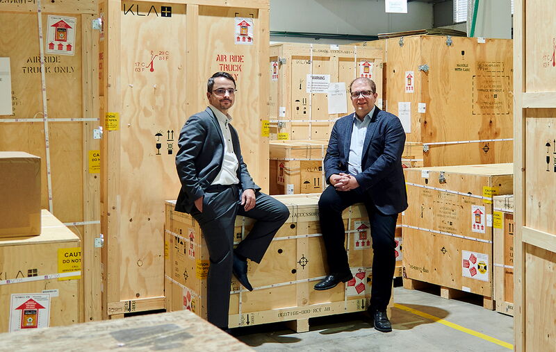 Fertig für den  Versand: Frank  Laske (links) und  Marcus Ritter  posieren für den  Fotografen im  Versand. Bis zu  26 Kisten sind  nötig, um eine  Anlage für den  Transport sicher  zu verpacken