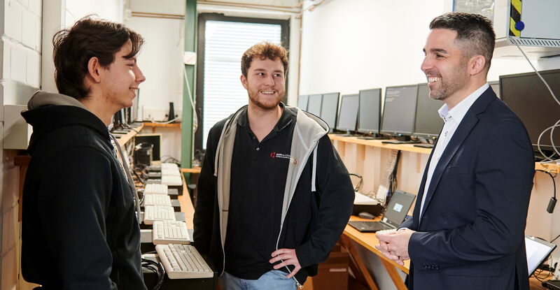 Azubis im Einsatz: Der Chef im Gespräch mit zwei Azubis. Die angehenden Fachinformatiker für Systemintegration konfigurieren Laptops für Schüler