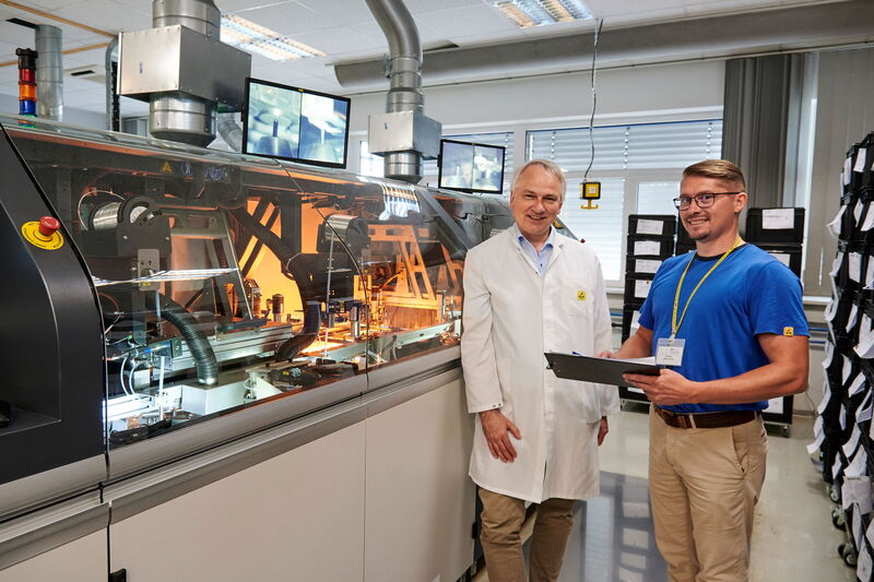 Fertigung rund um die Uhr: Oliver Brückmann und Produktionsleiter an einer selektiven Lötanlage zur Bestückung von Leiterplatten.