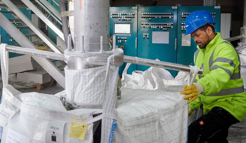 Abpackanlage:  Anlagenführer  Joseph Gebredidan verpackt  Pulver, das  Kabel für  Offshore-Anlagen widerstandsfähiger  macht