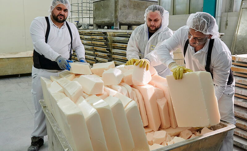 Lichtschutz für  Sonnencreme:  Hier nehmen  Produktionsmitarbeiter feinst  vermahlene, zu  Platten geformte Partikel  aus einer  Anlage