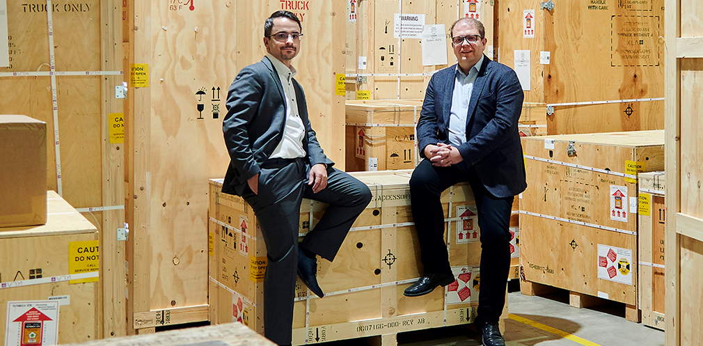 Fertig für den  Versand: Frank  Laske (links) und  Marcus Ritter  posieren für den  Fotografen im  Versand. Bis zu  26 Kisten sind  nötig, um eine  Anlage für den  Transport sicher  zu verpacken