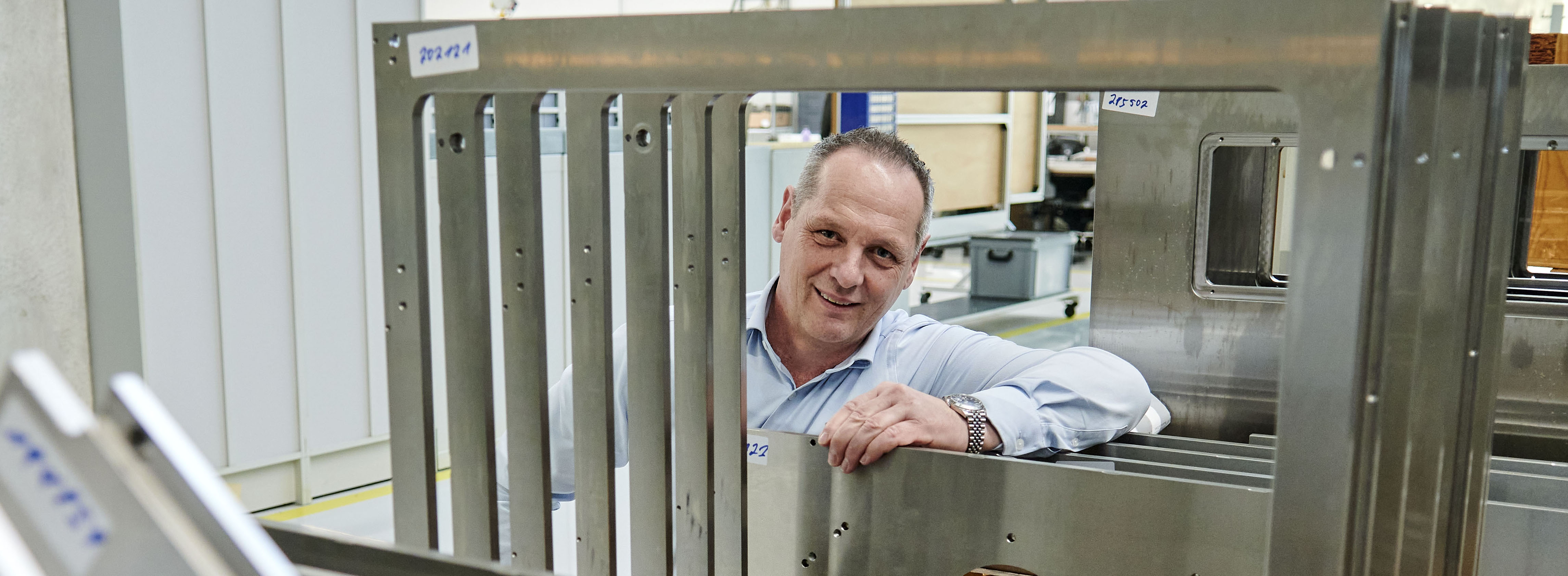 Produktionsleiter Dennis Baier ist hier umrahmt von Stahlbauteilen